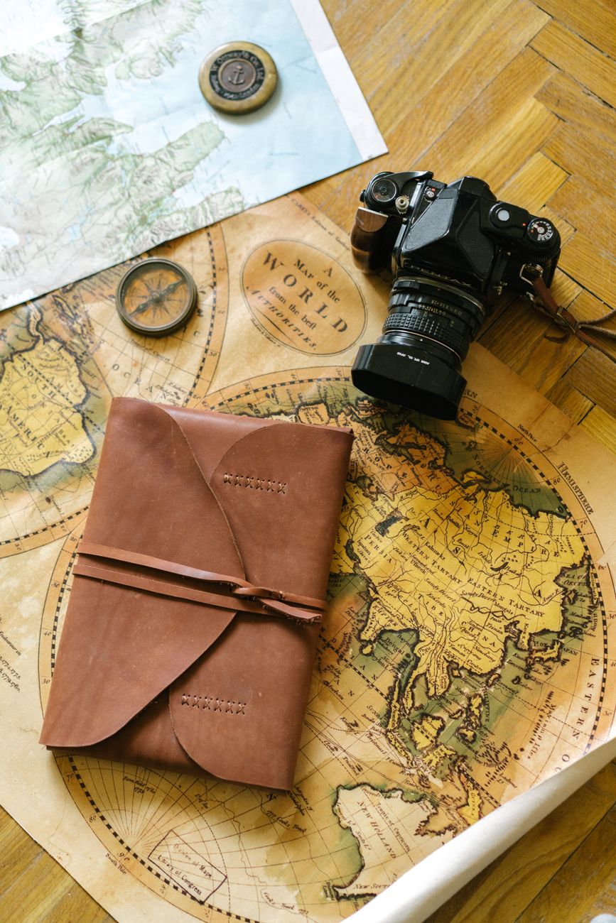 Editorial workdesk with travel notebooks, camera and maps